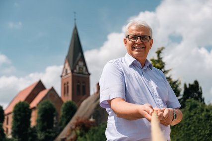 Ein Mann steht vor einer Kirche - Copyright: Oliver Beck